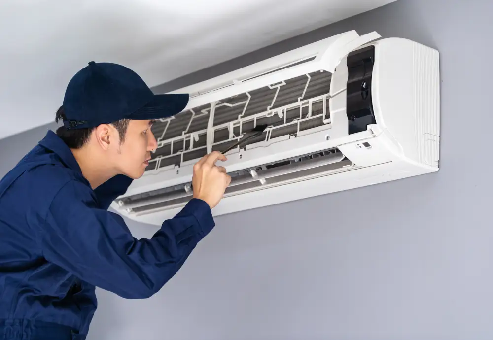 Certified AC repair technician fixing an indoor split air conditioning unit